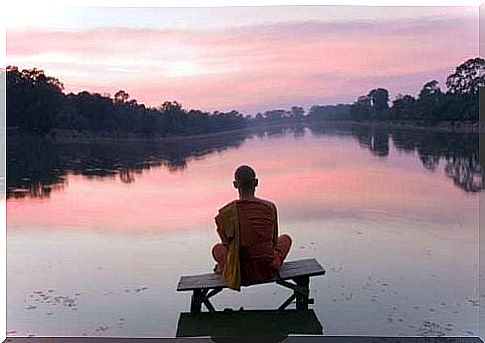 Monk meditates and thanks with Namaste